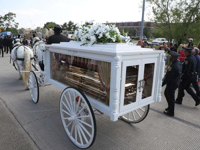 People watch as a horse drawn hearse containing the remains of George Floyd passes by during the funeral procession. Picture: AFP