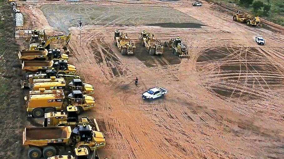 DRONE VIEW: Two protesters on 9m poles attached to Adani&#39;s Carmichael Mine vehicles have disrupted the mine&#39;s progress. Inset top: Brisbane climate protests. Inset bottom: FLAC protestor suspended. Picture: FLAC