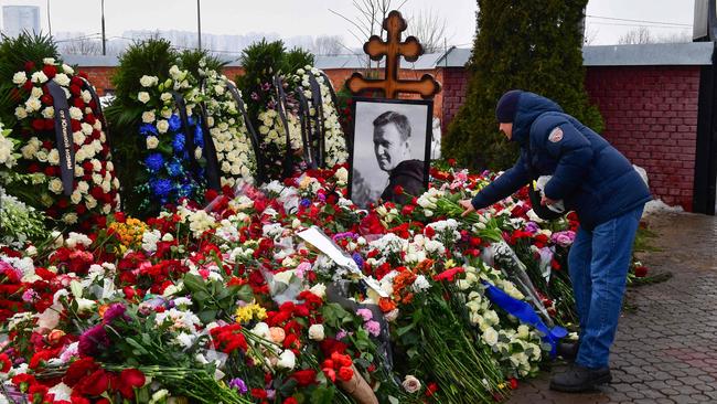 A mourner lays flowers on the grave of Russian opposition leader Alexei Navalny at the Borisovo cemetery in Moscow the day after Navalny's funeral. Picture: Olga MALTSEVA/AFP