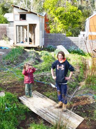 The boys standing next to the backyard veggie patch.