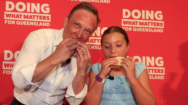 Queensland Premier Steven Miles eats a sandwich with his daughter Bridie, 10, at his campaign launch at the North Lakes Community Centre. Picture: Adam Head