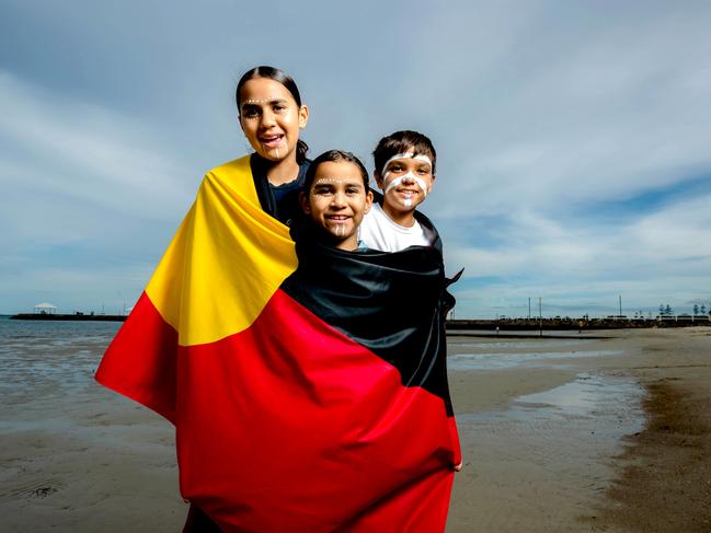 Melanie La Frentz, Alyssa La Frenz and Jamarley Edey from Wynnum with the Aboriginal Flag. Picture: Richard Walker