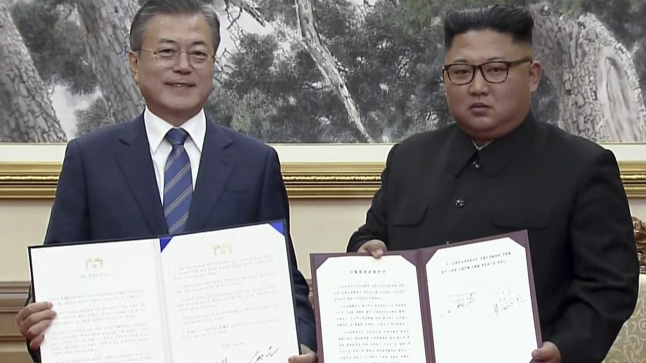 In this image made from video provided by Korea Broadcasting System (KBS), the two leaders pose after signing documents in Pyongyang.