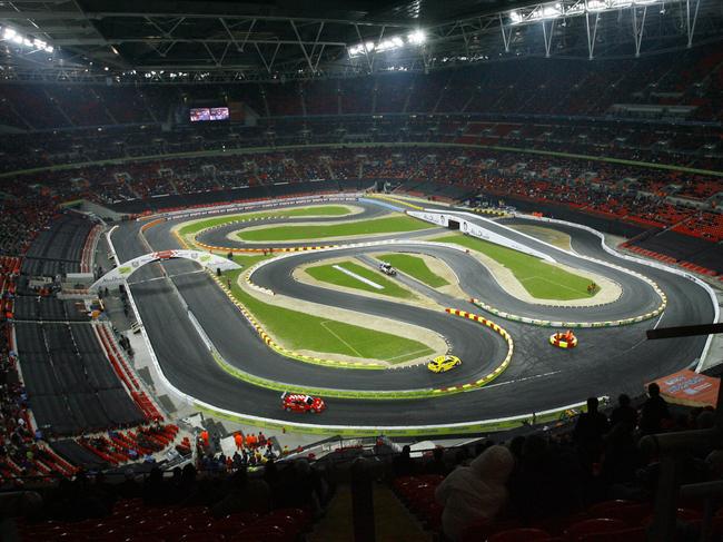 Two competitors compete in the Race of Champions at Wembley Stadium, London, Sunday Dec. 16, 2007. Seven-times Formula One world champion Schumacher was partnered by current Toro Rosso driver Sebastian Vettel as Germany beat Finland in the final in the end-of-year spectacular.The world's best drivers from various disciplines were in competition against one another on a giant 'Scalextric' track built inside the stadium. (AP Photo/Tom Hevezi)