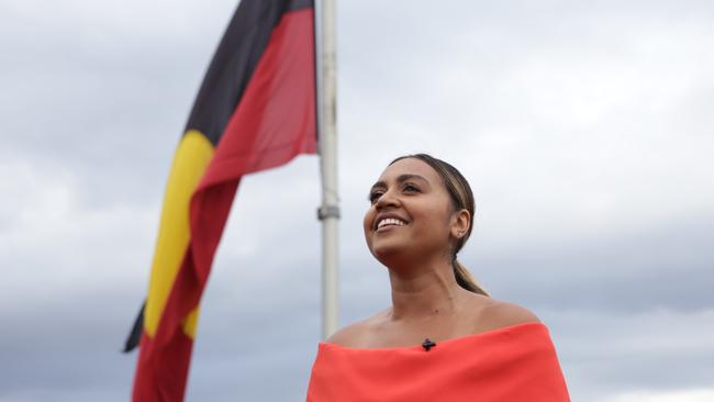 Jessica Mauboy celebrates Australia Day on top of the Sydney Harbour Bridge with the Aboriginal Flag. Pic: Gareth Christian / The Australia Day Council of NSW