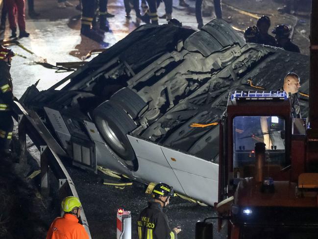 Emergency crew members work at the scene after the bus accident. Picture: Getty Images