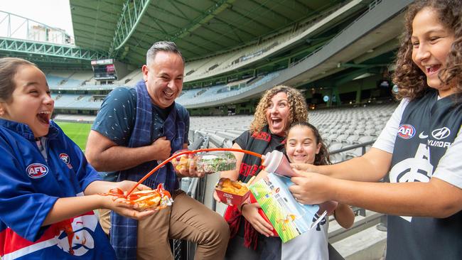 Footy fans Katherine and Vincent Ruiu with their kids Mattea, Abigale and Anthony celebrate the cheaper food prices at Marvel Stadium this season. Picture: Jay Town