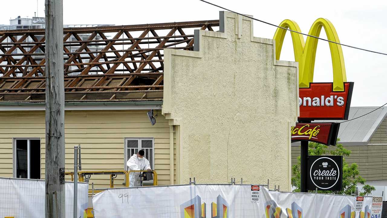 Workers remove the roof from the old firemans hall in Limestone Street in preparation for its demolition to extend the McDonald's carpark. Picture: Rob Williams