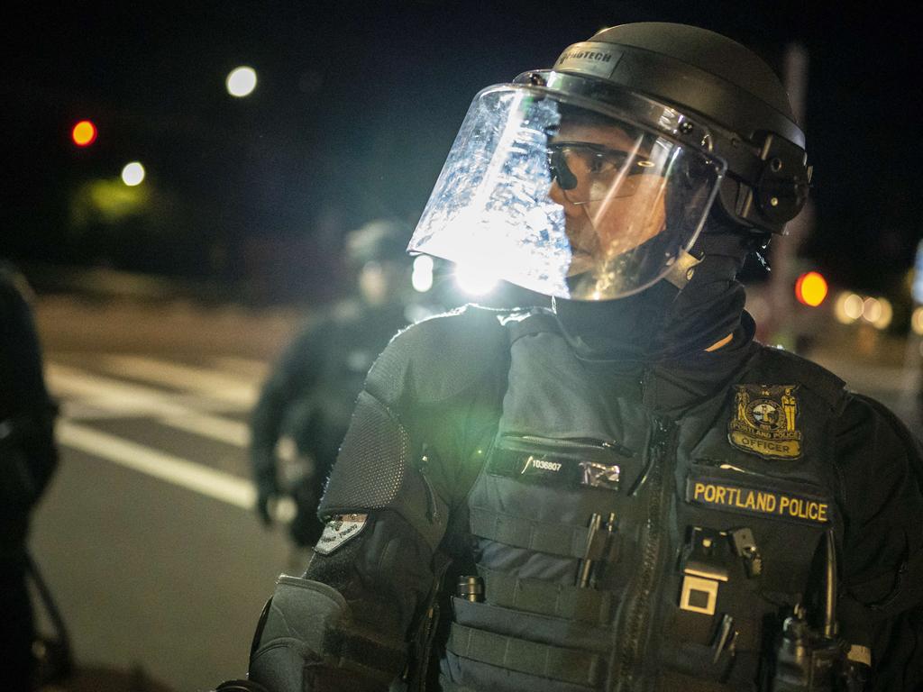 Portland police dispersing a crowd after protesters set fire to the Portland Police Association (PPA) building. Picture: Nathan Howard