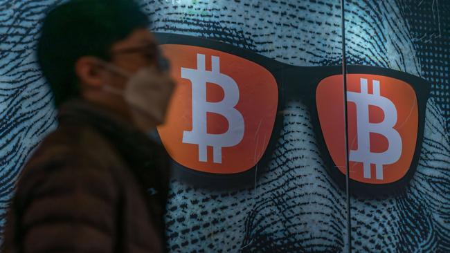 HONG KONG, CHINA - FEBRUARY 15: Pedestrians walk past a display of cryptocurrency Bitcoin on February 15, 2022 in Hong Kong, China. Cryptocurrencies are gaining popularity worldwide as investors seek to diversify into the new asset class despite wild swings in the valuations of assets like Bitcoin and Ethereum in the first weeks of the year. Buying and selling crypto is becoming common in many places, like Hong Kong, where regulators have so far avoided using a heavy hand to manage crypto platforms. (Photo by Anthony Kwan/Getty Images)