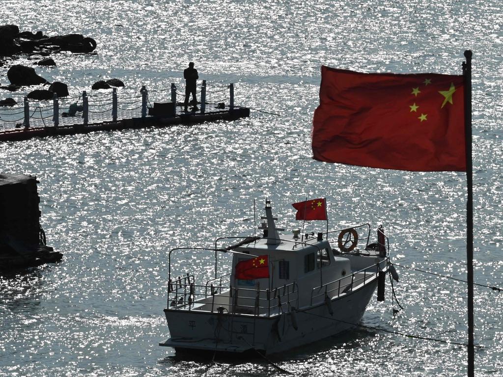 A tourist boat and Chinese flags on Pingtan island, opposite Taiwan, in China’s southeast Fujian province on Sunday. China was conducting a second day of military drills around Taiwan in what it has called a "stern warning". Picture: Greg Baker/AFP