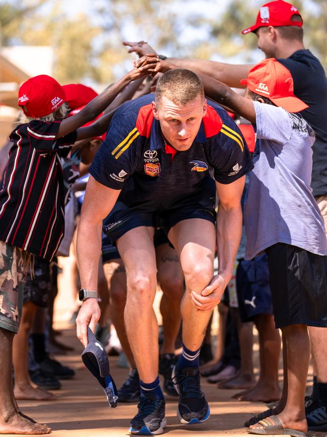 Reilly O’Brien with children in the APY Lands on a trip up north. Picture: AFC