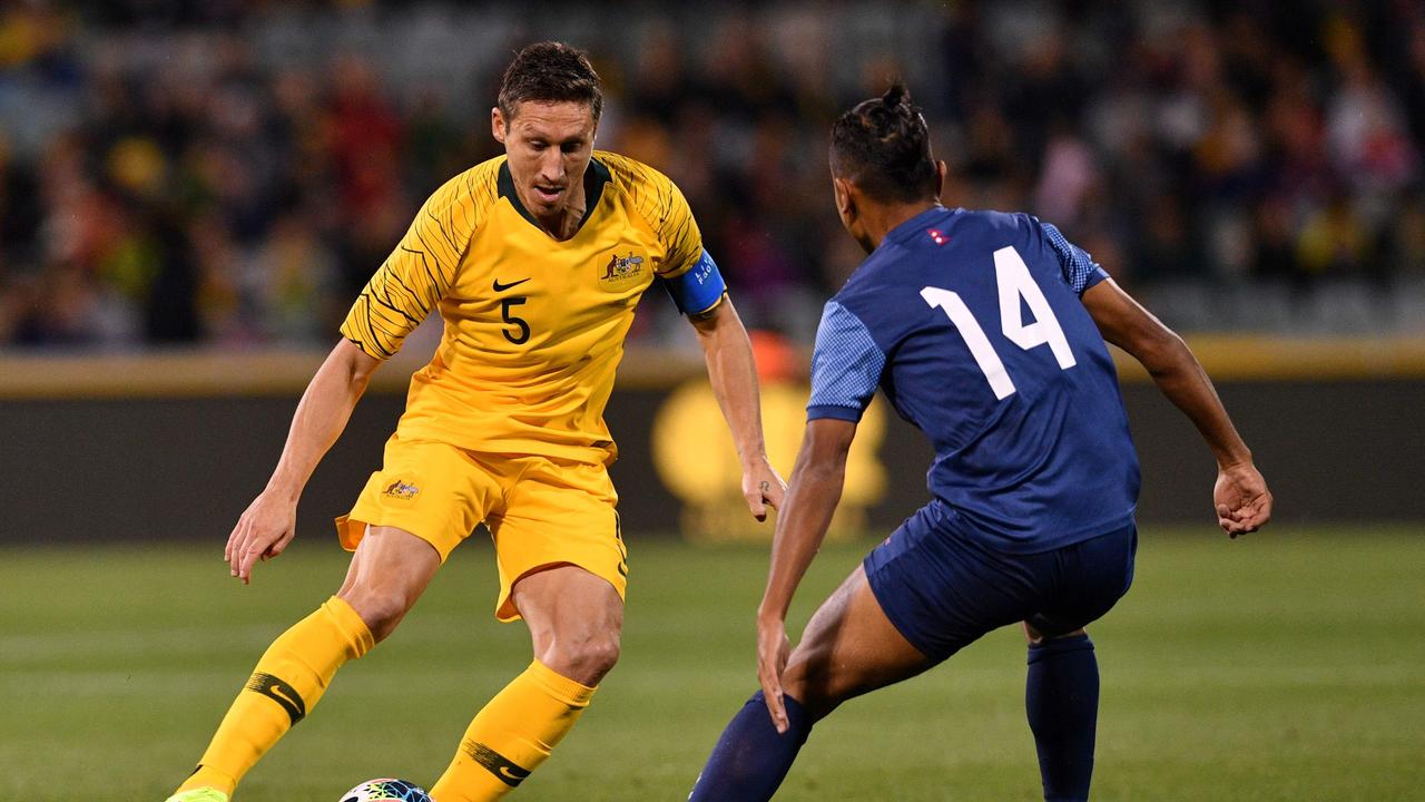 Australia's Mark Milligan (L) is challenged by Nepal's Anjan Bista in the World Cup Qatar 2022 qualification round 2 football match between Australia and Nepal at the GIO Stadium in Canberra on October 10, 2019. (Photo by SAEED KHAN / AFP) / — IMAGE RESTRICTED TO EDITORIAL USE — STRICTLY NO COMMERCIAL USE —