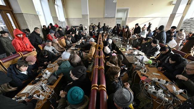 Kherson residents charge their phones at the city's train station as the city's critical infrastructure including power and water supplies were destroyed.