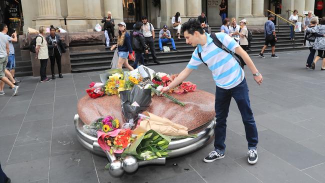 A man lays flowers at Bourke St Mall. Picture: Alex Coppel