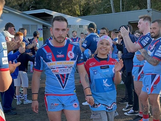 Dora Creek Swampies player Kendyll Fahey leading the team out with Imohgen Alo at Dora Creek Workers Club Oval on July 28, 2024. The club put on a fundraising day for the 10-year-old, who is receiving treatment for T-cell lymphoma. Picture: supplied