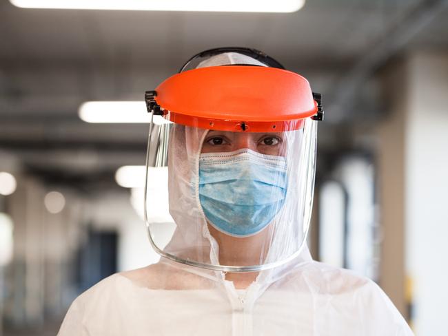 Coronavirus COVID-19 virus disease global pandemic outbreak,UK NHS frontline medical key worker,EMS Personal Protective Equipment, posing for a portrait at parking lot hallway, emergency ICU Intensive Care Unit first responder