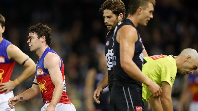 Neale walks away from field umpire Mathew Nicholls with blood streaming from his head.