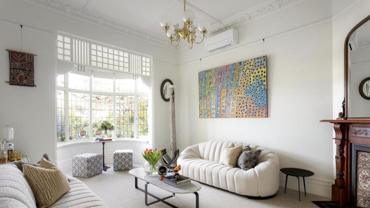 The formal lounge showcases original Edwardian features including leadlight bay windows, high ceilings and ornate fireplace detail.