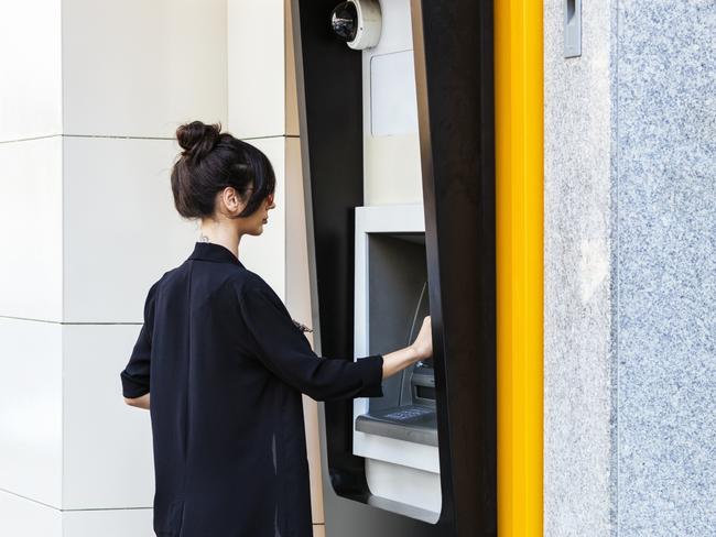 Businesswoman using ATM in city