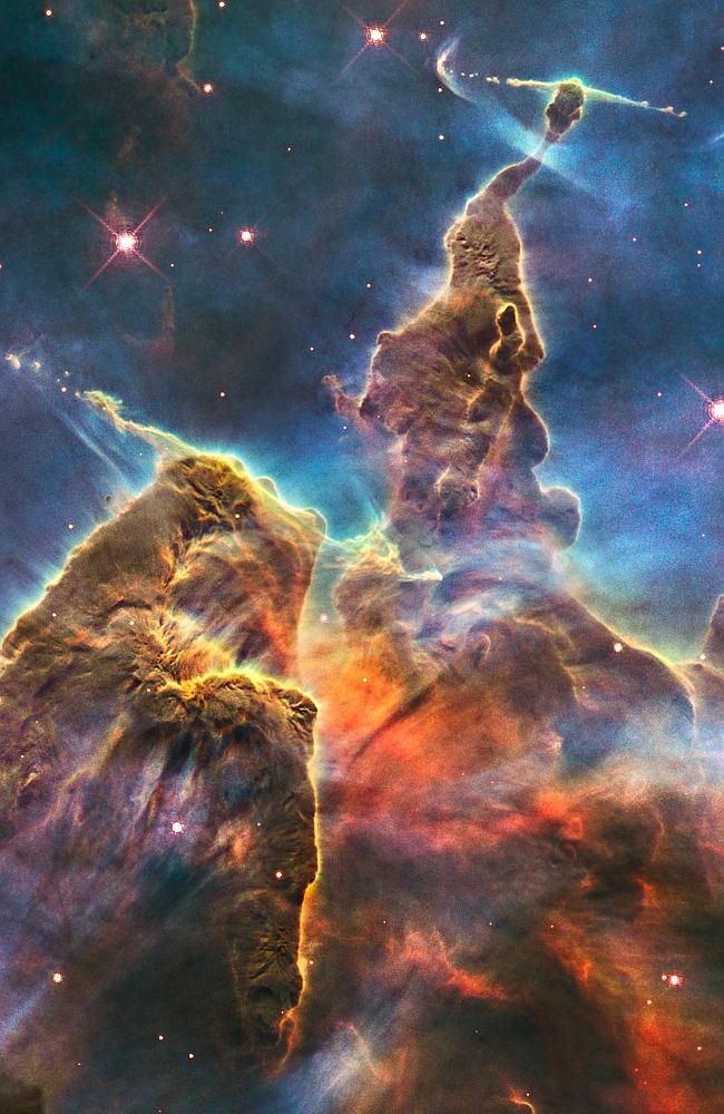 This craggy fantasy mountaintop enshrouded by wispy clouds looks like a bizarre landscape from Tolkien's The Lord of the Rings. The NASA/ESA Hubble Space Telescope image, which is even more dramatic than fiction, captures the chaotic activity atop a pillar of gas and dust, three light-years tall, which is being eaten away by the brilliant light from nearby bright stars.