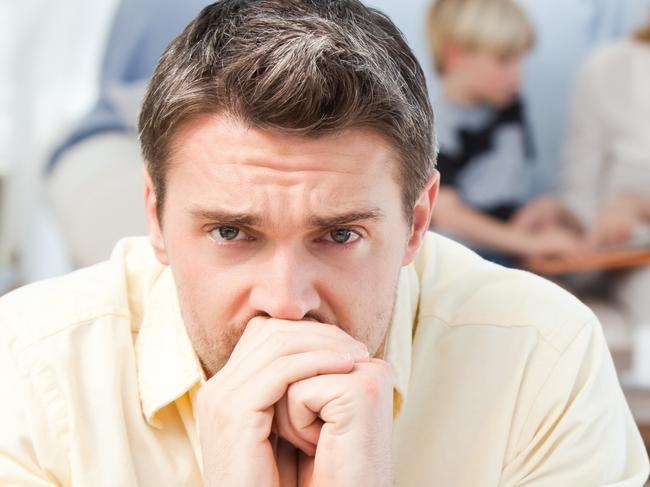 MORTGAGE STRESS .. Man calculating his bills while his family are on the sofa Picture: Thinkstock