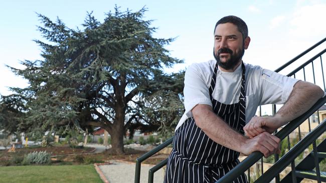 Mark Wilson is head chef at one of Hobart’s newest eateries — Restaurant Deodara at magnificent Maylands Lodge. Behind him is the tree after which the restaurant is named. Picture: LUKE BOWDEN