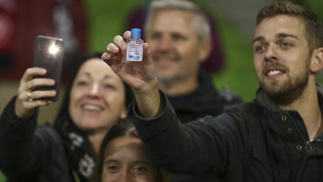 A fan offers players hand sanitiser during the match. Picture: Getty Images