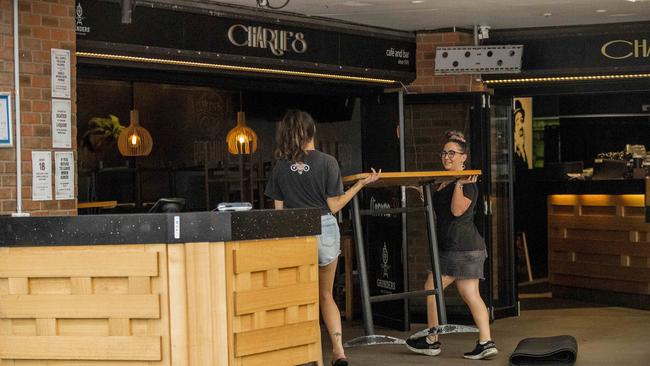 Staff at Charlie's Cafe &amp; Bar in Surfers Paradise putting furniture away. Picture: Jerad Williams