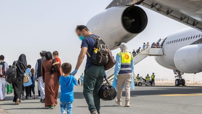 Afghanistan evacuees board a flight to Australia from the Australian Defence Force's main operating base in the Middle East region.