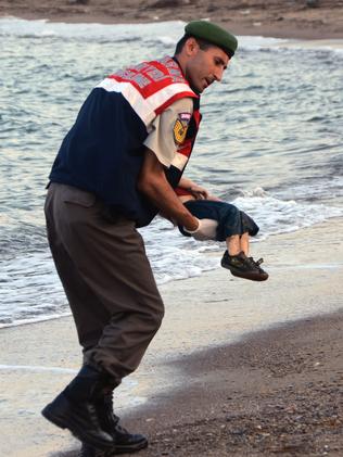 ADDS IDENTIFICATION OF CHILD A paramilitary police officer carries the lifeless body of Aylan Kurdi, 3, after a number of migrants died and a smaller number were reported missing after boats carrying them to the Greek island of Kos capsized, near the Turkish resort of Bodrum early Wednesday, Sept. 2, 2015. The family — Abdullah, his wife Rehan and their two boys, 3-year-old Aylan and 5-year-old Galip — embarked on the perilous boat journey only after their bid to move to Canada was rejected. The tides also washed up the bodies of Rehan and Galip on Turkey's Bodrum peninsula Wednesday, Abdullah survived the tragedy. (AP Photo/DHA) TURKEY OUT