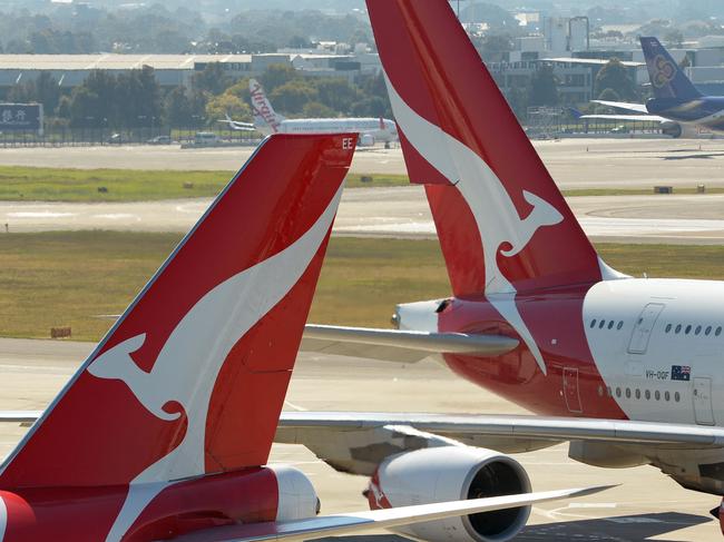 (FILES) This file photo taken on August 28, 2013 shows Qantas aircraft on the tarmac at Sydney's International Airport. - Australian flag carrier Qantas on August 20, 2020 posted an almost 2 billion USD annual loss after a "near-total collapse" in demand due to the COVID-19 coronavirus pandemic. (Photo by Greg WOOD / AFP)