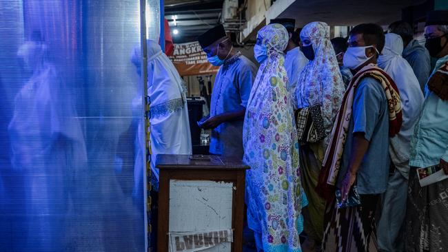 The faithful queue for a disinfectant chamber after prayers at Yogyakarta’s Jogokaryan Mosque to mark the start of Ramadan. Picture: Getty Images