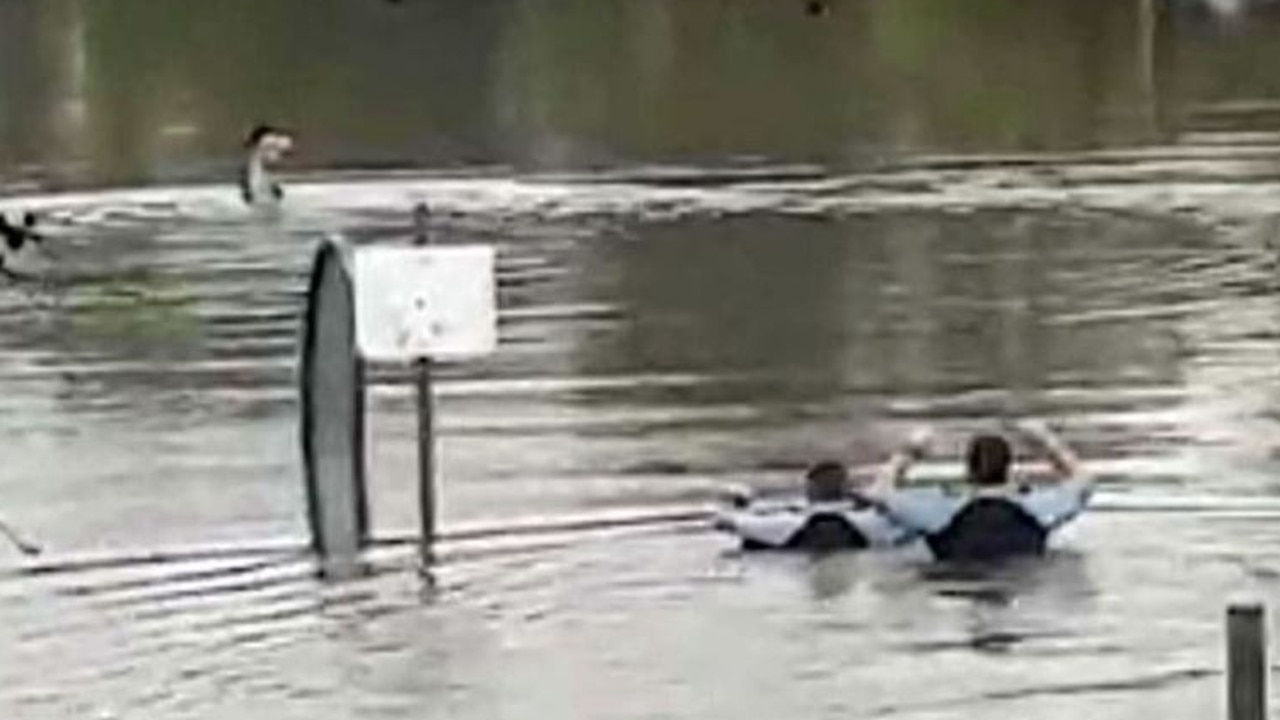 The police officers wade into the freezing floodwaters to perform the rescue. Picture: 9 News