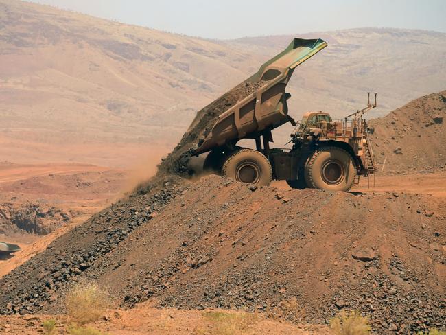 An autonomous haul truck dumps a load of rock in the mine pit at Rio Tinto Group's Gudai-Darri iron ore mine in the Pilbara region of Western Australia, Australia, on Thursday, Oct. 19, 2023. Rio Tinto is preparing for trials of battery-powered locomotives in Australia, where it uses giant autonomous trains — the world’s largest and longest robots — to transport iron ore across the vast Outback. Photographer: Carla Gottgens/Bloomberg