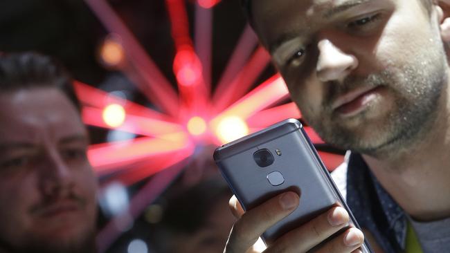 Two men look at a LePro 3 phone. Picture: Jeff Chiu/AP