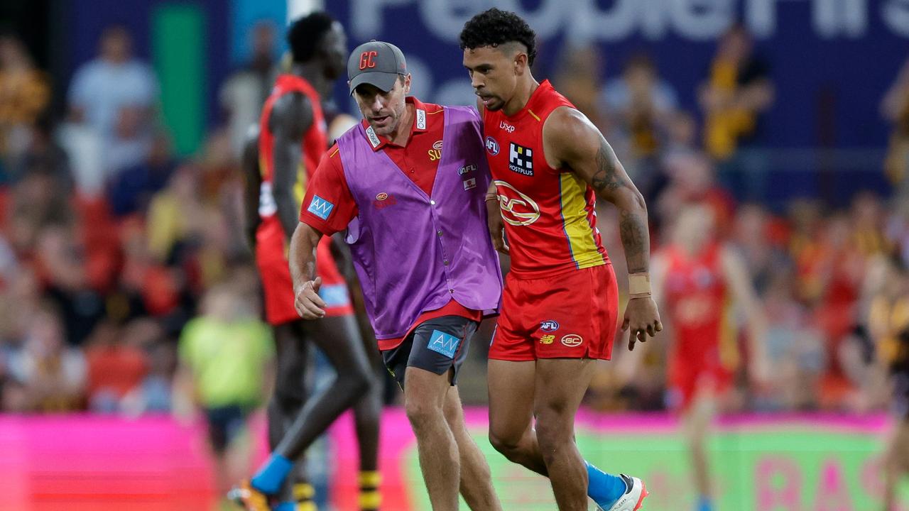 Malcolm Rosas of the Suns is helped off the ground against Hawthorn. Picture: Getty Images