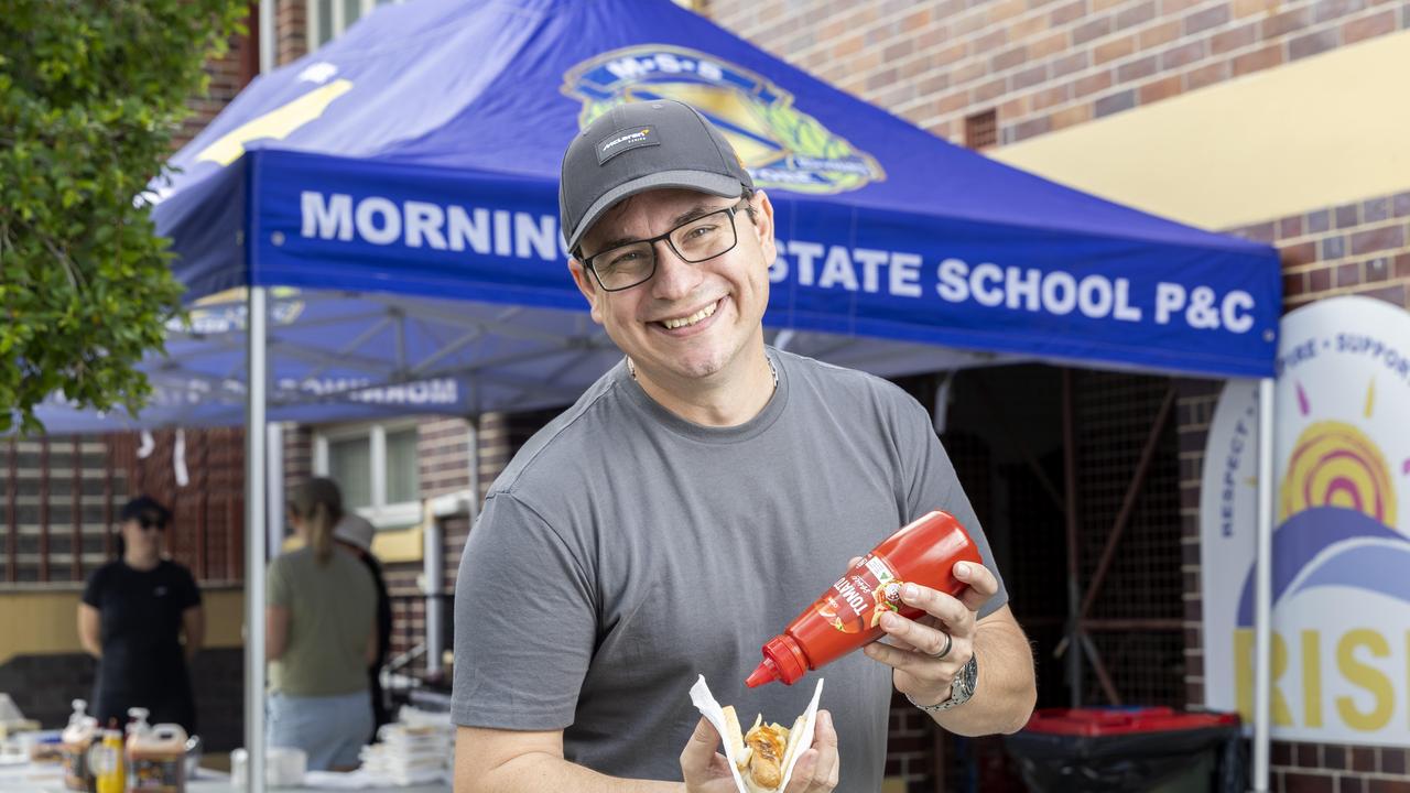 Chris Gilbert sauces up his democracy sausage at Morningside State School. Picture: Richard Walker