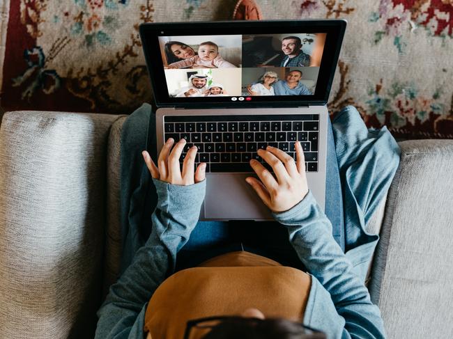 Young woman using a laptop to connect with her friends and parents during quarantine. She's having a video conference during Coronavirus COVID-19 time.