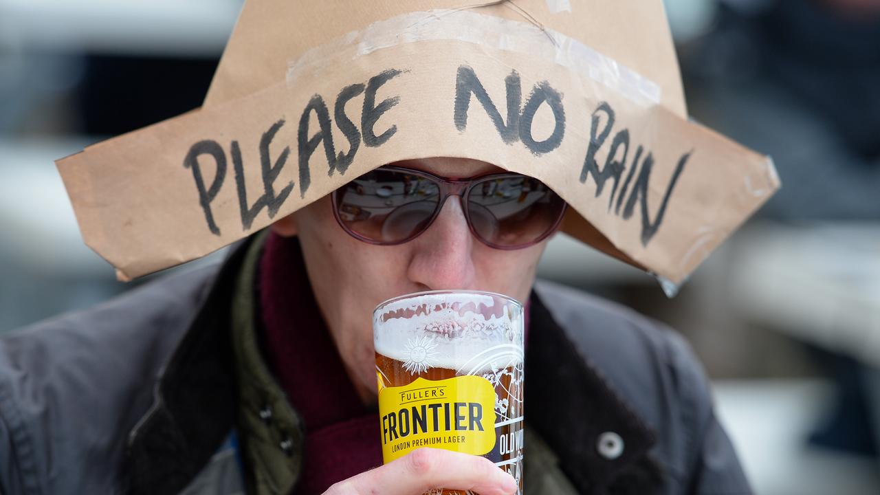 A drinker at The Still and West pub in Portsmouth, England on the first day of pubs reopening in England. It did indeed rain. (Photo by Finnbarr Webster/Getty Images)