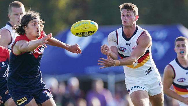 Matt Crouch of the Crows handballs from Luke Jackson of the Demons during the AFL Marsh Community Series pre-season match between the Melbourne Demons and Adelaide Crows at Casey Fields in Melbourne, Saturday, February 22, 2020. (AAP Image/Michael Dodge)