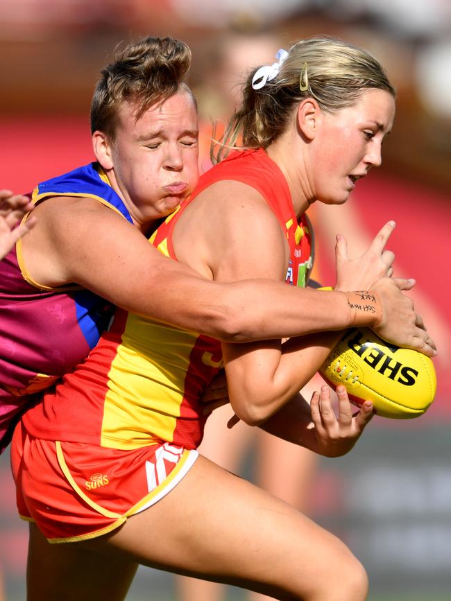 Dee Heslop (right) of the Suns is tackled by Dakota Davidson (left) of the Lions during the Round 3 AFLW match between the Gold Coast Suns and Brisbane Lions at Metricon Stadium on the Gold Coast, Saturday, February 22, 2020 (AAP Image/Darren England)