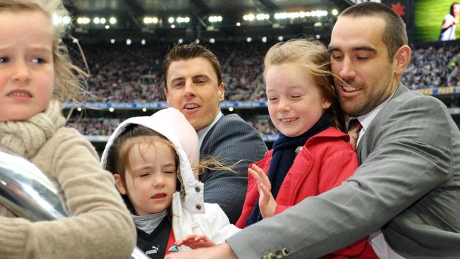 Matthew Lloyd and Scott Lucas (and kids) take part in the 2009 grand final motorcade.