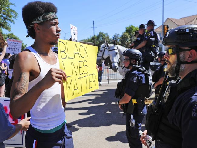 A protester and police face each other during a demonstration near a private event attended by President Donald Trump. Picture: AP