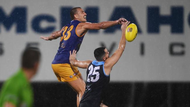 Wanderers ruck Mathew Motlop flys over Buffalo's player Christopher Atkinson in round 1 of the NTFL 22/23 season. Picture: (A)manda Parkinson