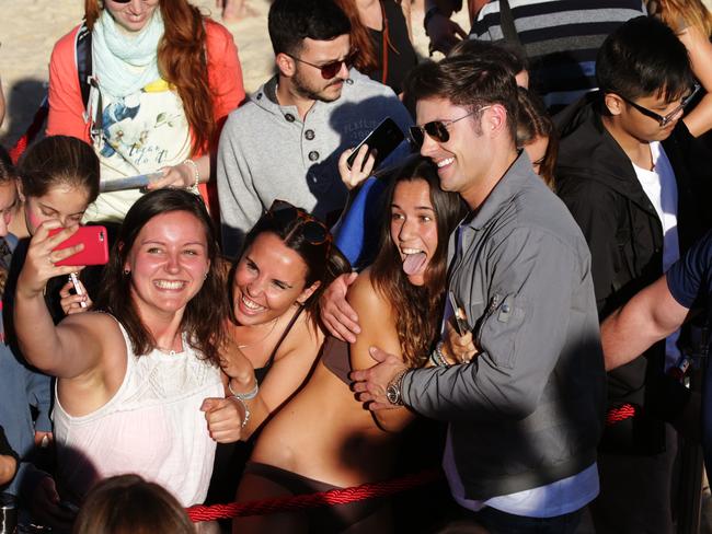 Zac Efron poses with fans for photos on Bondi beach. Picture: Toby Zerna