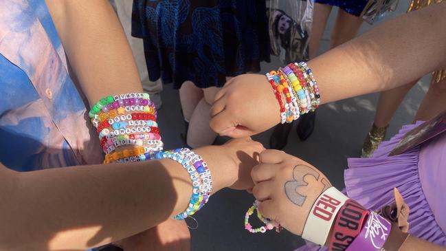 Friends Jack O’Neill and Fritzie Juaneza show off their friendship bracelets outside the MCG. Picture: Angus McIntyre