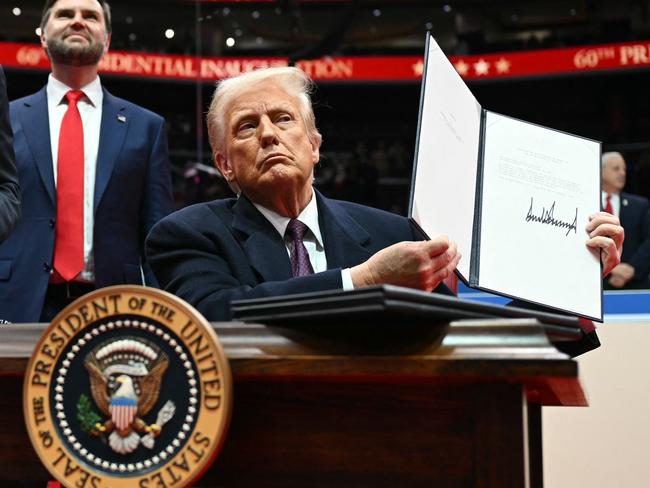 US President Donald Trump holds letter to the UN stating the US withdrawal from the Paris Agreement during the inaugural parade inside Capital One Arena, in Washington, DC, on January 20, 2025. (Photo by Jim WATSON / AFP)