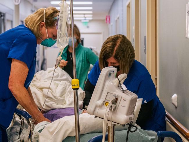 HOUSTON, TEXAS - AUGUST 18: Emergency room nurses tend to a patient in a hallway at the Houston Methodist The Woodlands Hospital on August 18, 2021 in Houston, Texas. Across Houston, hospitals have been forced to treat hundreds of patients in hallways and corridors as their emergency rooms are being overwhelmed due to the sharp increase in Delta variant cases. Hospitals are straining to keep up with the surge of new coronavirus patients as schools and businesses continue to reopen. Houston has seen an upward increase in Delta infections, and research is showing the Delta variant to be 60% more contagious than its predecessor the Alpha variant, also known as COVID-19.   Brandon Bell/Getty Images/AFP == FOR NEWSPAPERS, INTERNET, TELCOS & TELEVISION USE ONLY ==