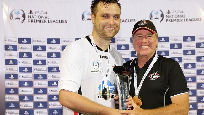 Zachary Cairncross and coach Mark Crittenden of Blacktown City hold the National Premier League Grand Final trophy.